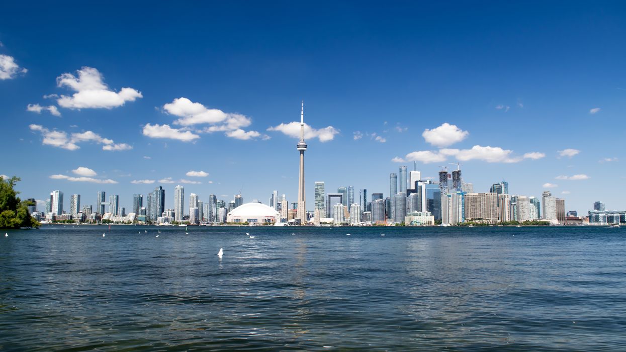 Panoramic view of Toronto's skyline with Lake Ontario in the foreground.