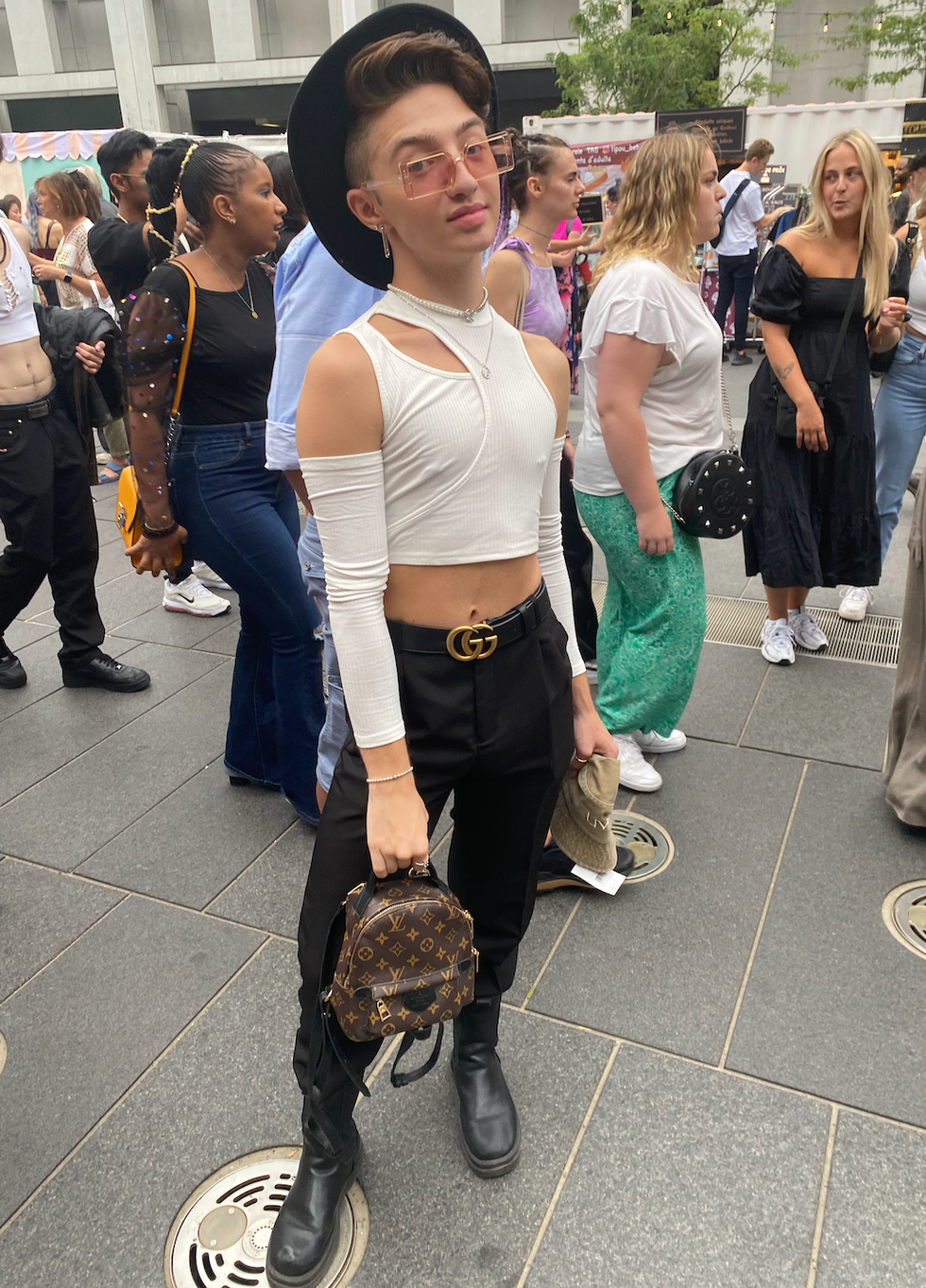 Pantalon noir structur\u00e9, chandail blanc asym\u00e9trique, ceinture Gucci et sac Louis Vuitton.