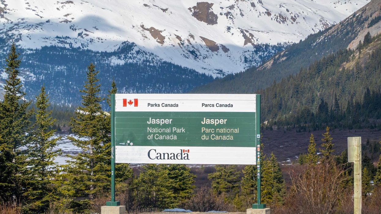 parks canada sign in jasper with mountains in the background