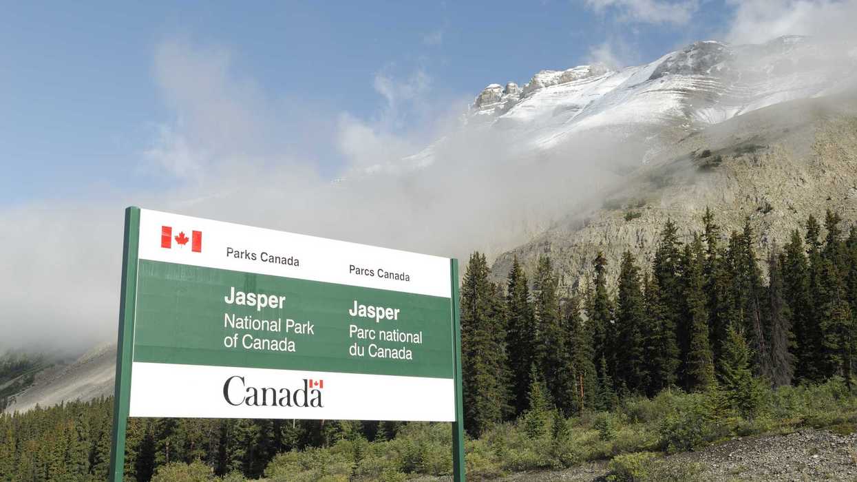 parks candaa sign at jasper national park in front of snow capped mountains