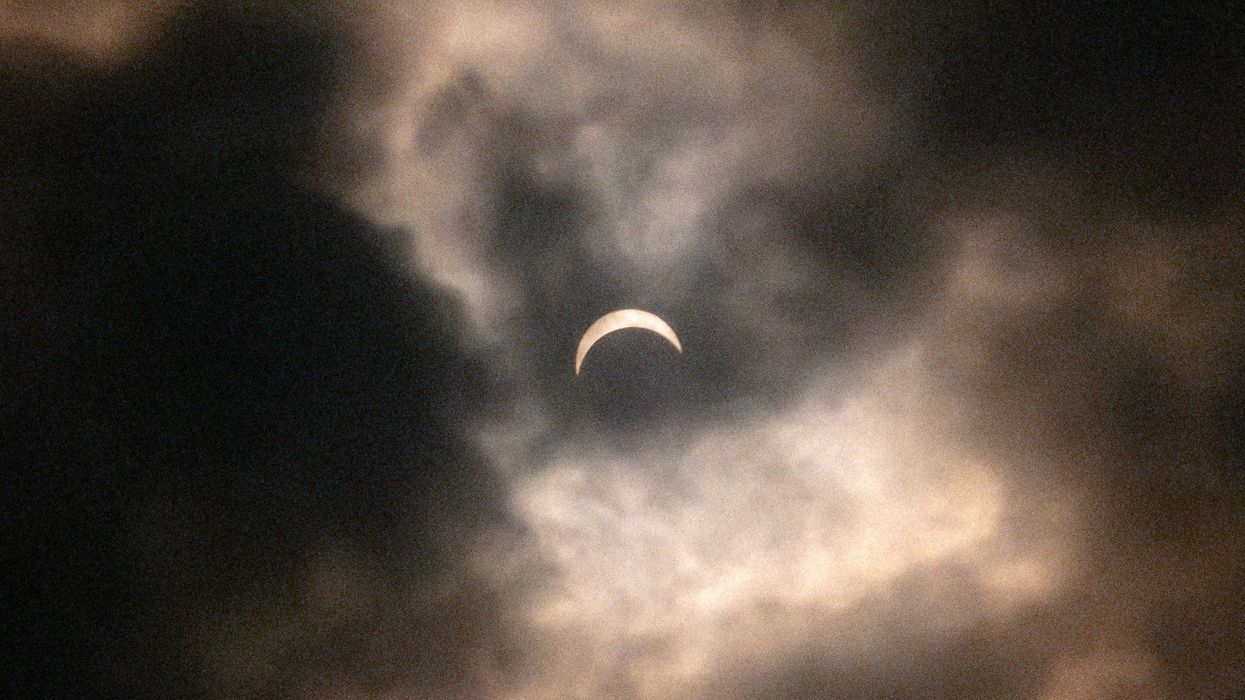 partial solar eclipse behind clouds