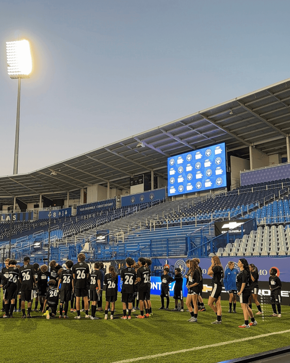 Participants at Stade Saputo join CF Montr\u00e9al players on the pitch.
