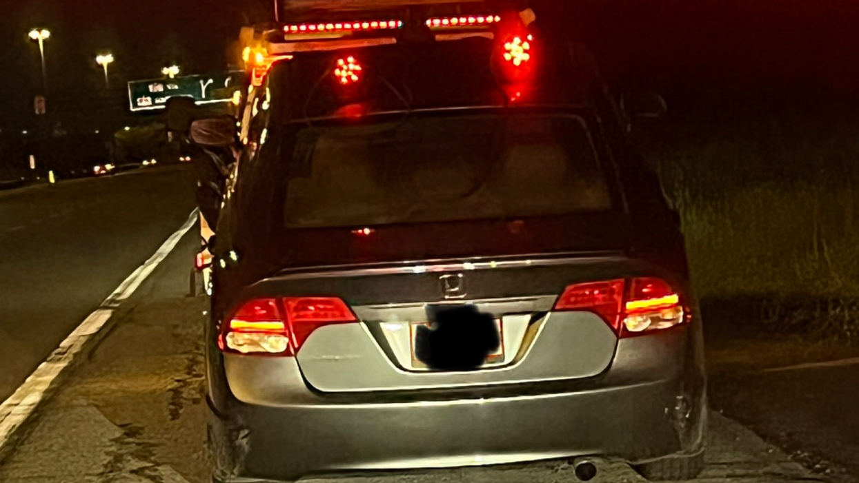 Passenger vehicle being impounded on roadside.