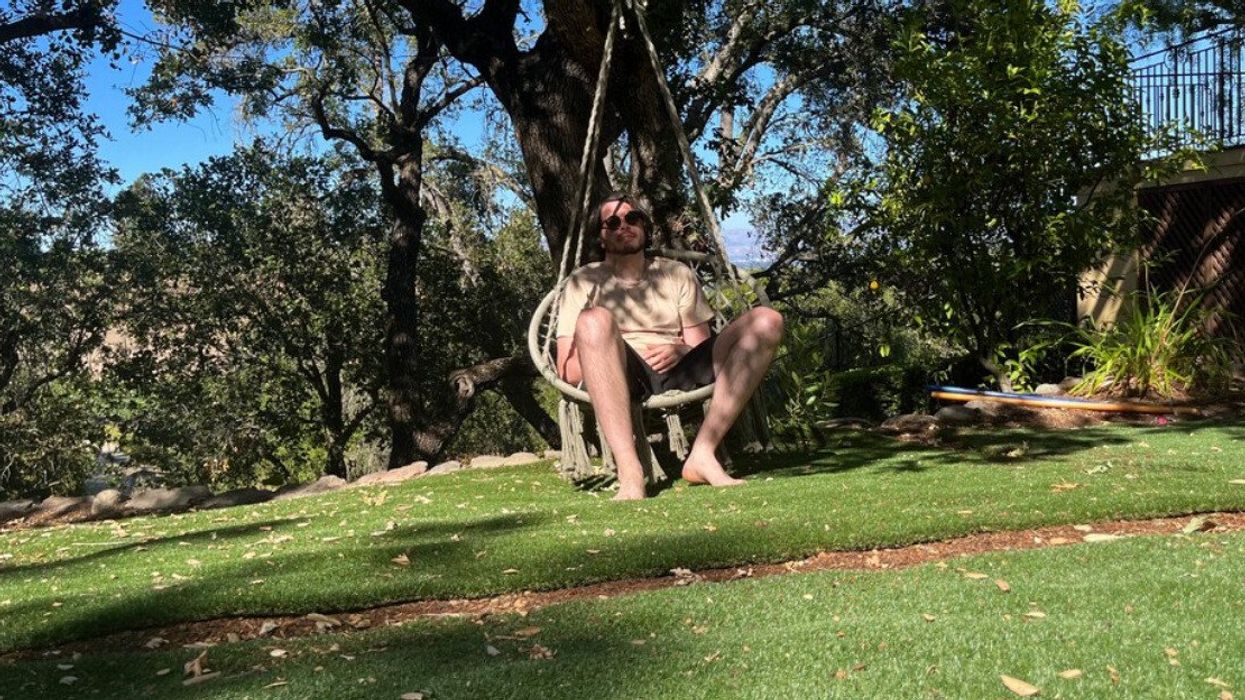 Patrick sitting on a backyard swing