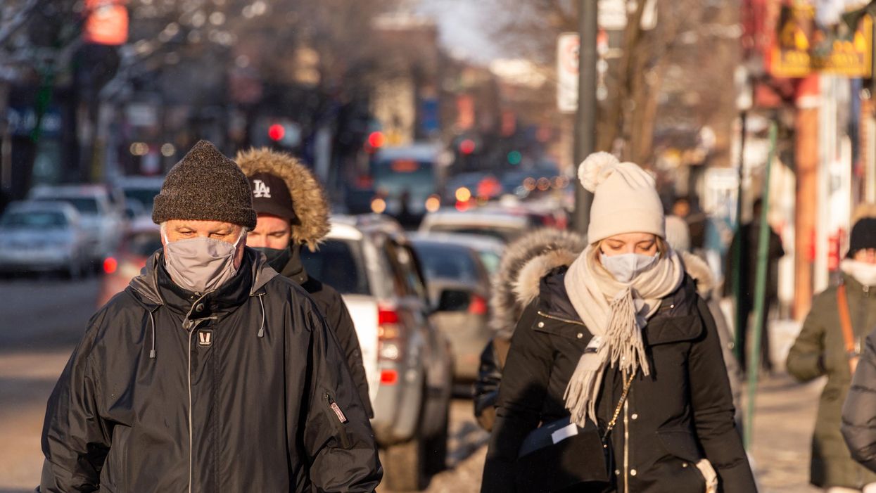 Pedestrians wearing masks on the street.
