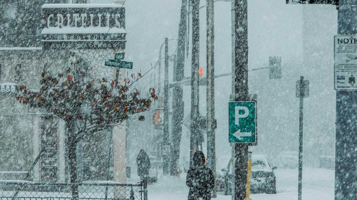 people and cars along an ontario street during snowstorm
