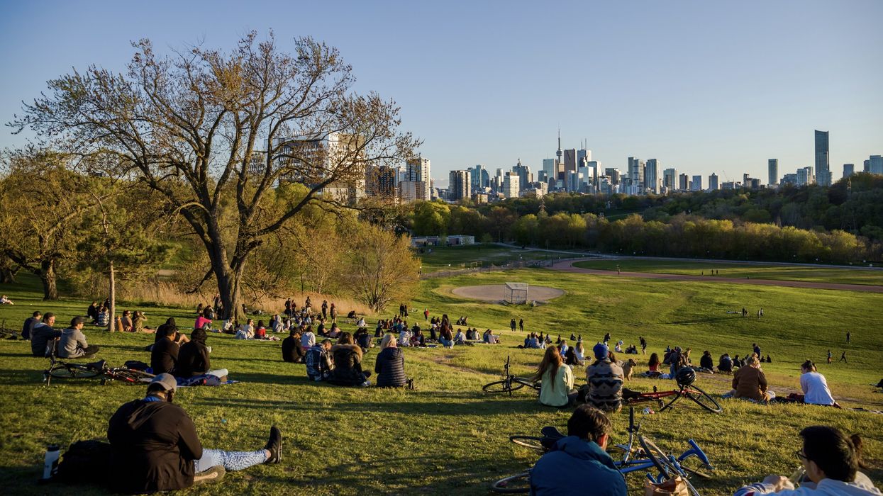 People at Riverdale Park East with the Toronto skyline in the background.