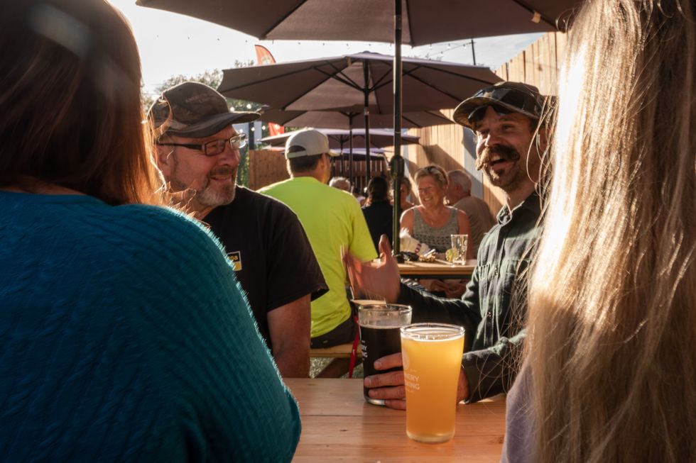 People chatting and enjoying their craft beer at the Cannery Backyard.