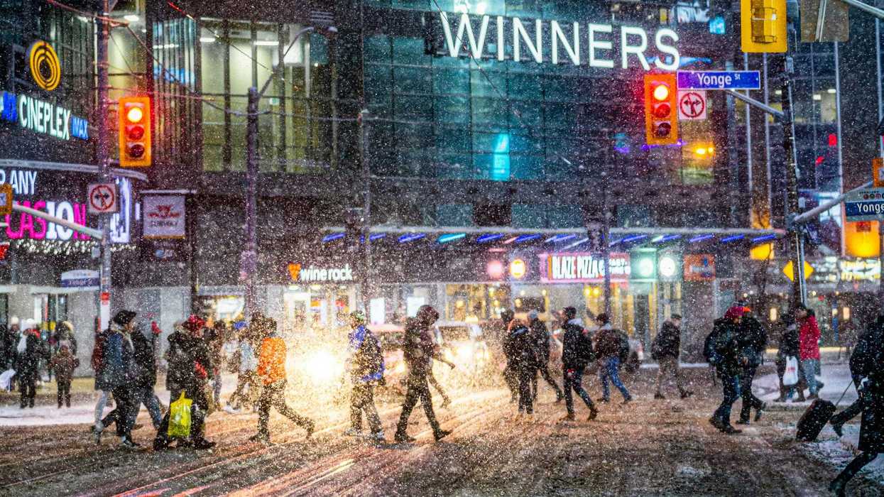 people crossing at yonge street in toronto during a snowstorm
