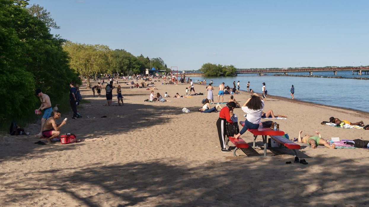 People enjoying a warm summer day at the beach on Centre Island in Toronto.