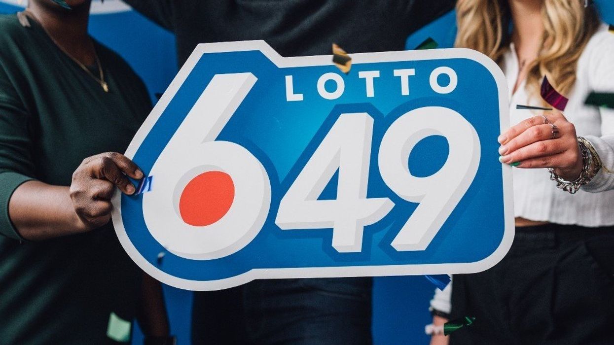 People holding a Lotto 6/49 sign as confetti falls.