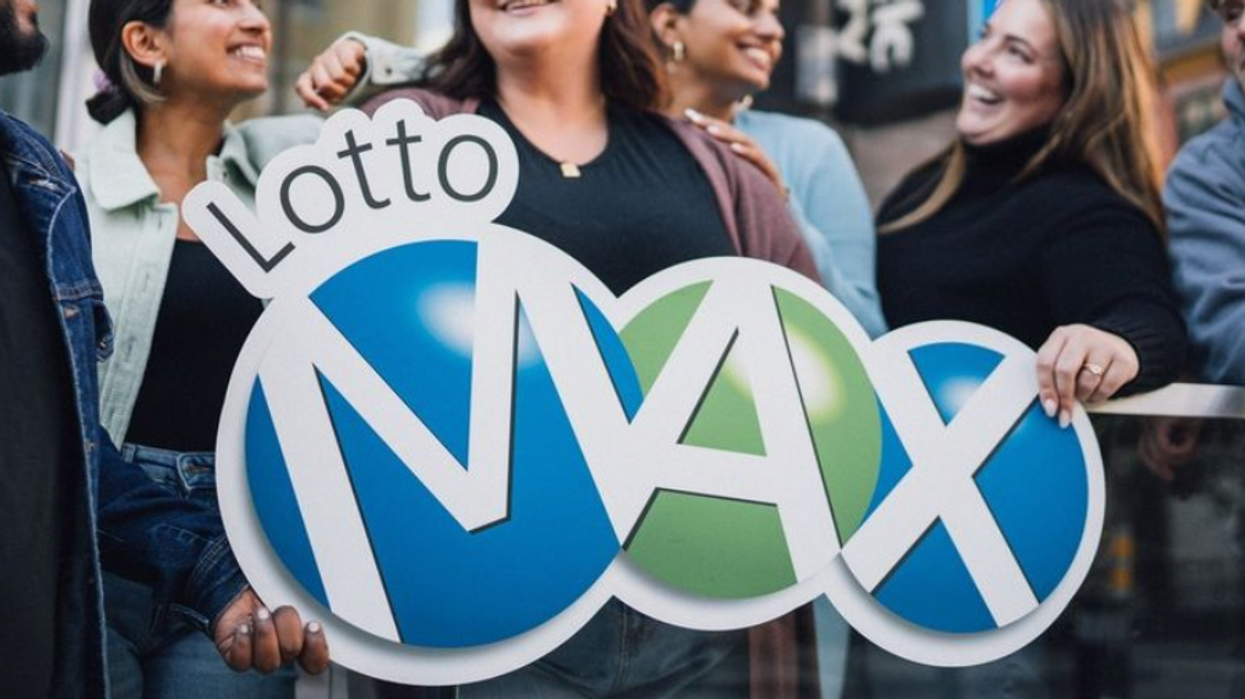 People holding a Lotto Max sign.