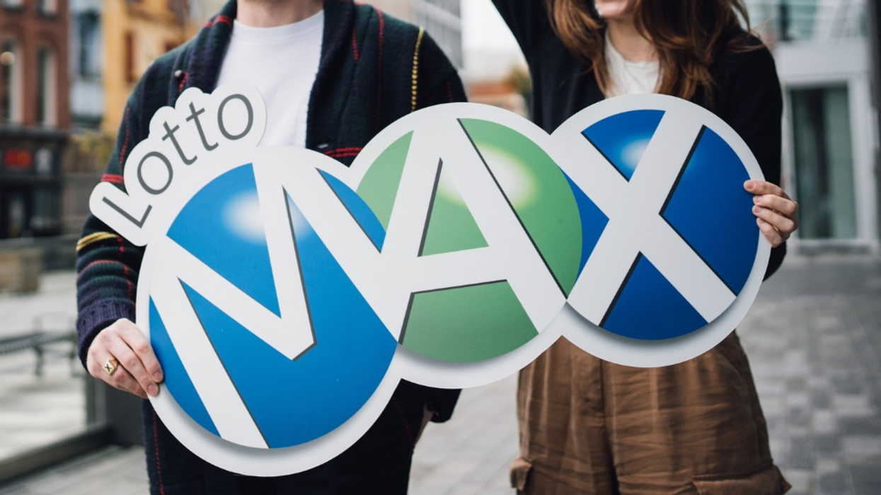 People holding a Lotto Max sign.