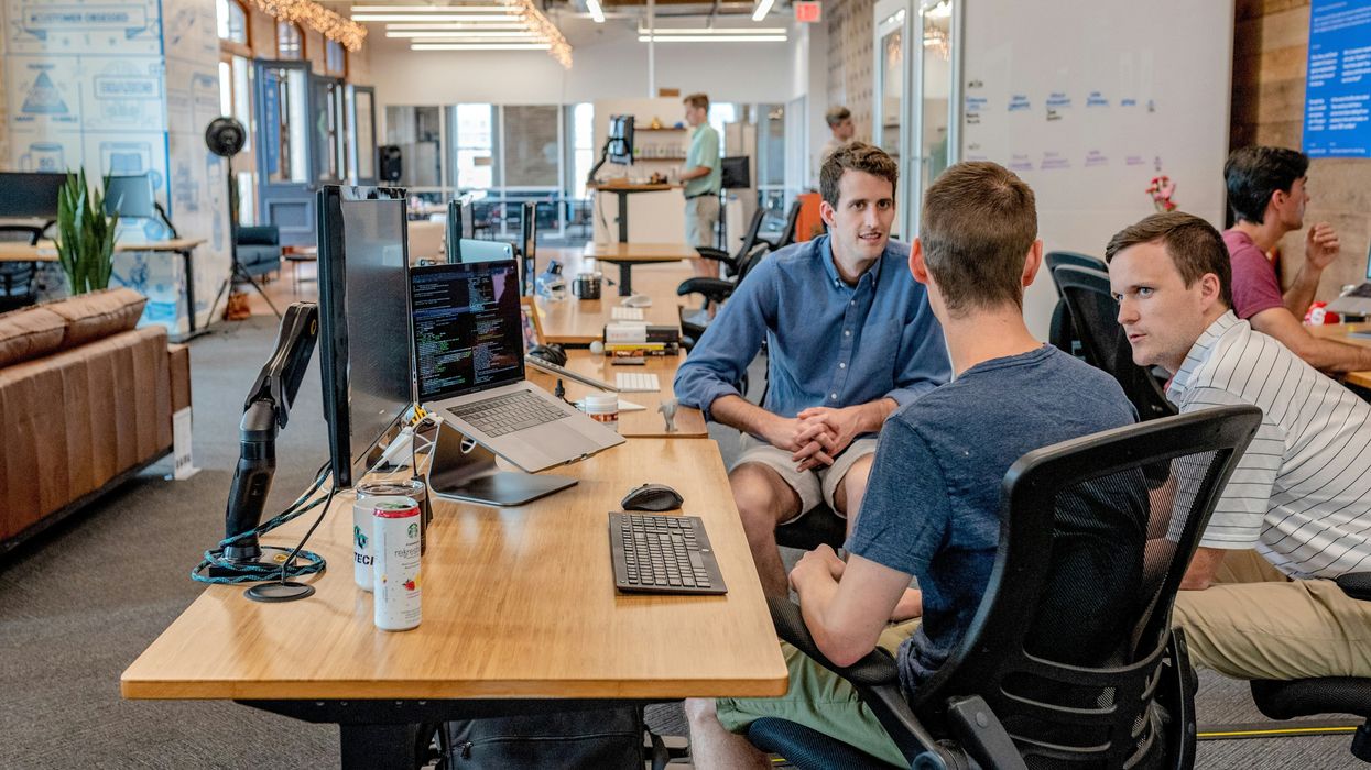 people in an office working on computers at desks
