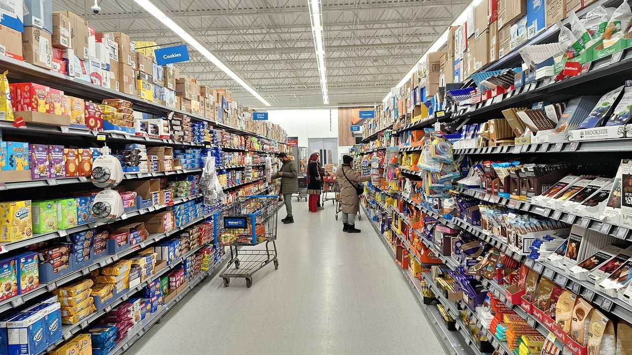 people in snack aisle with chocolate and candy at grocery store in canada