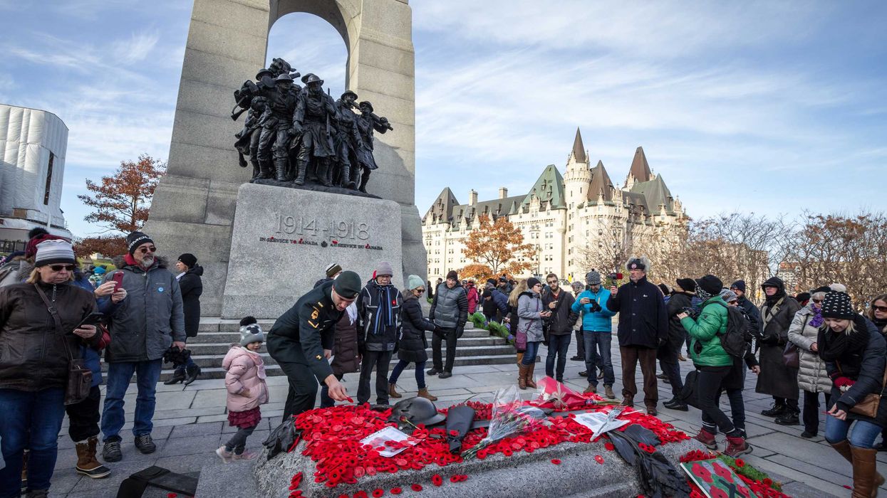 People lay poppies at the Tomb of the Unknown Soldier in Ottawa in a Remembrance Day ceremony.