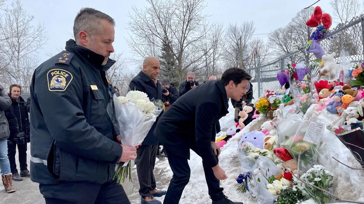People laying flowers at the daycare centre for the victims of the Laval bus crash.