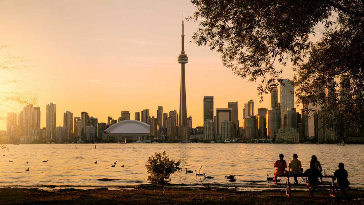 people looking at toronto skyline at sunset on toronto island