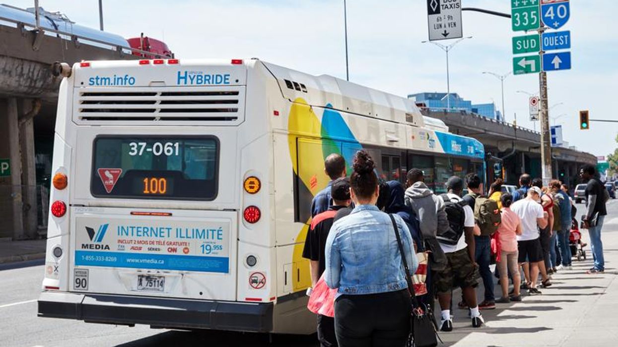 People queue up to get into a bus in Canada.