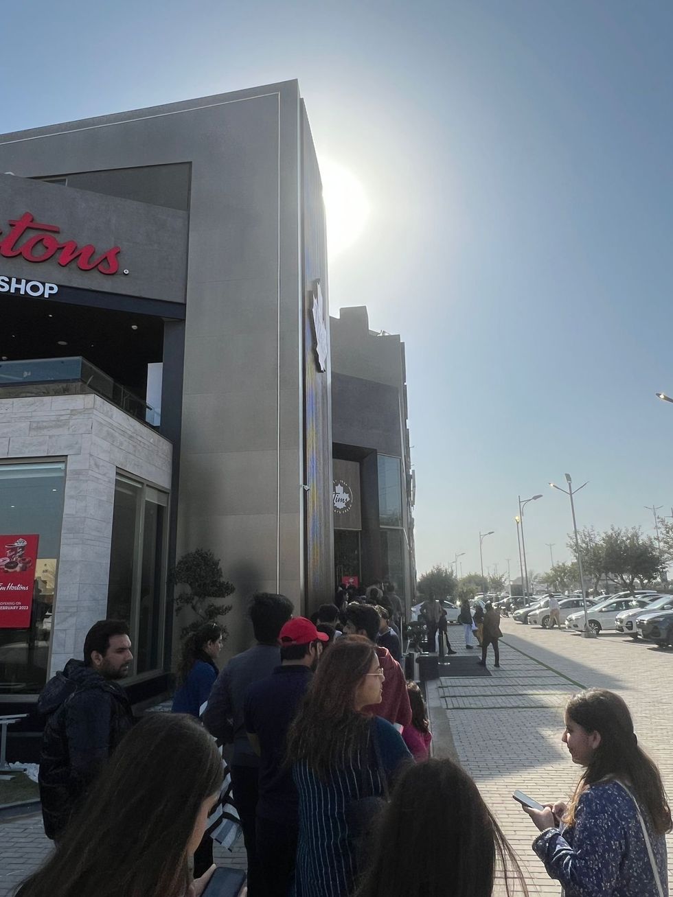 People waiting in a queue outside the Tim Hortons in Lahore.