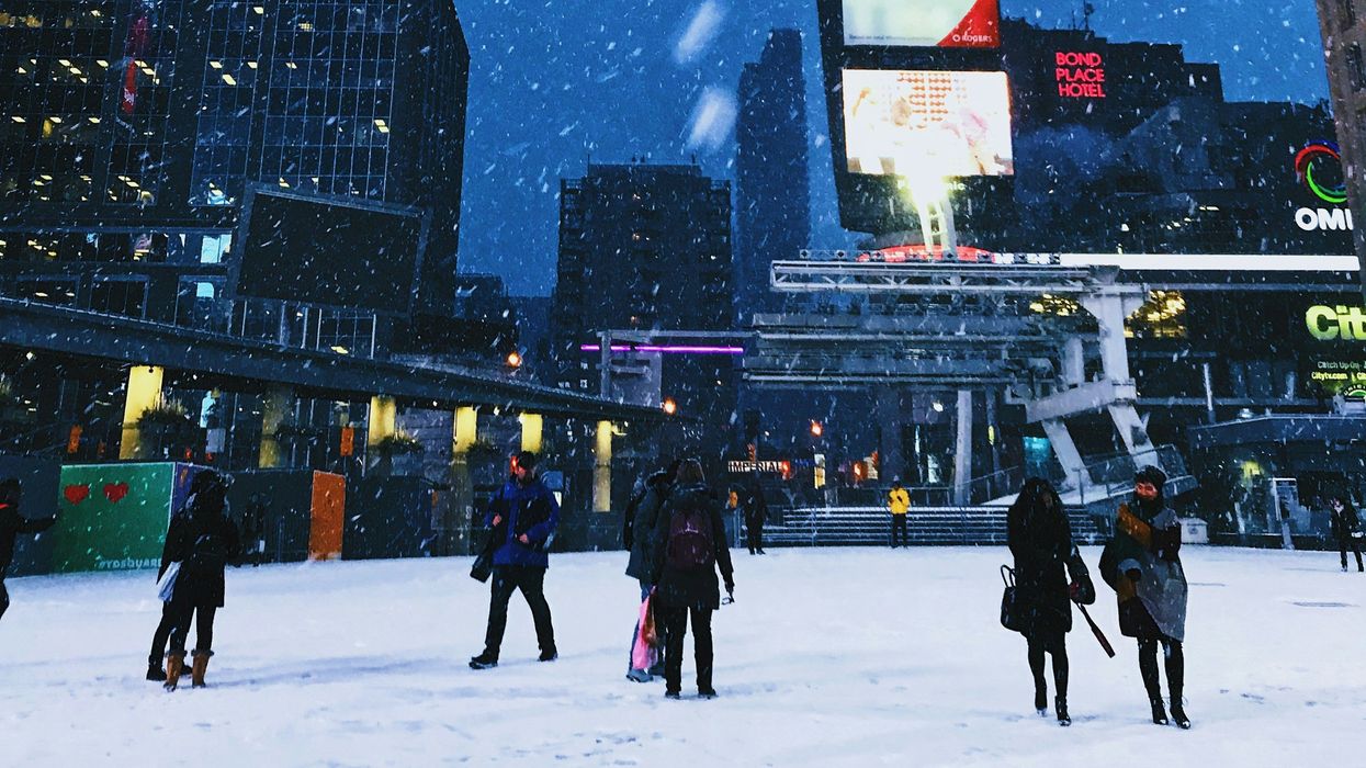 people walking in downtown toronto while it snows