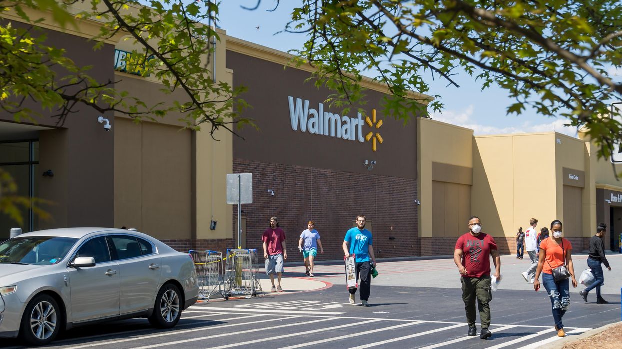People walking in front of a Walmart store.