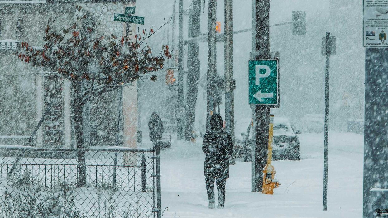 people walking on a side walk in st catharines ontario during a snowstorm