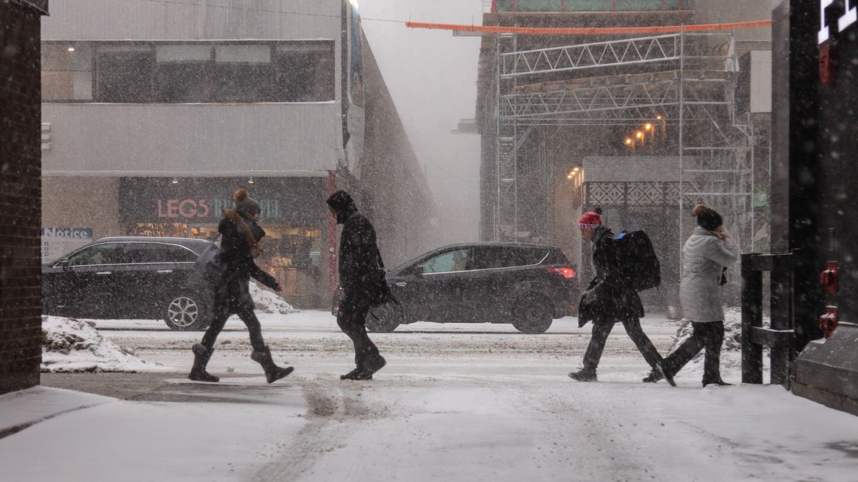 People walking through the street during a snowstorm in Toronto.