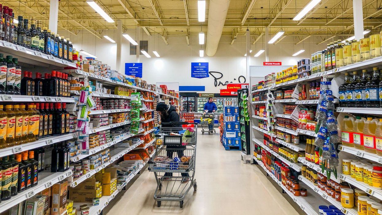 people with carts in an aisle at a grocery store in toronto, ontario