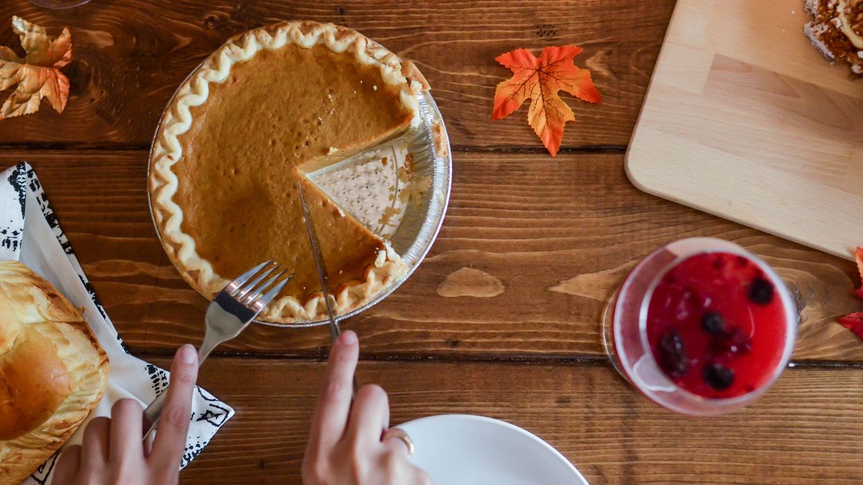 Person cuts a slice of pie to enjoy at Canadian Thanksgiving