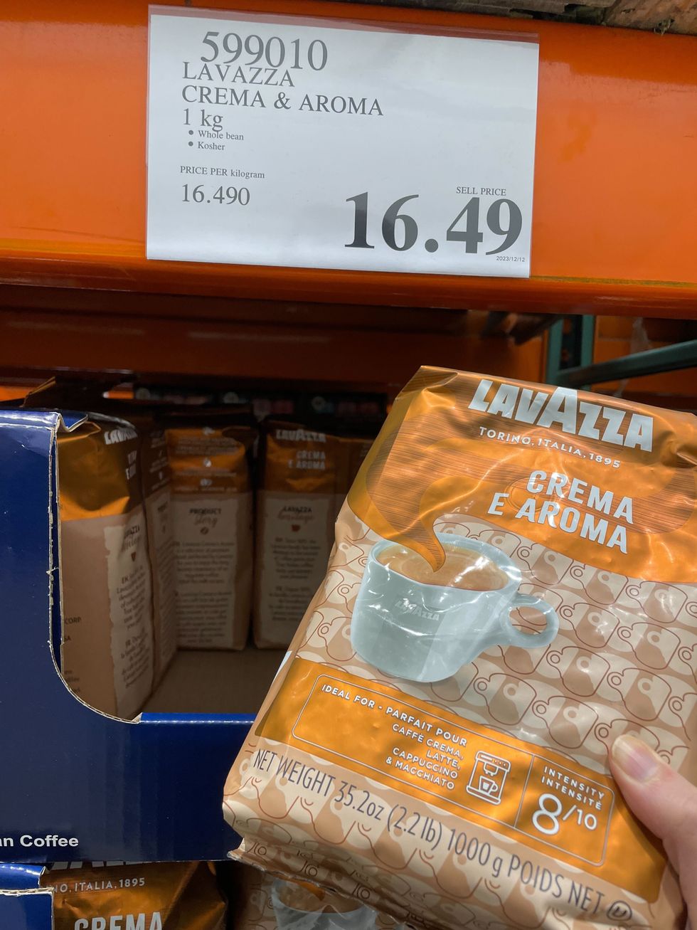 person holding a bag of lavazza crema e aroma coffee in a costco warehouse