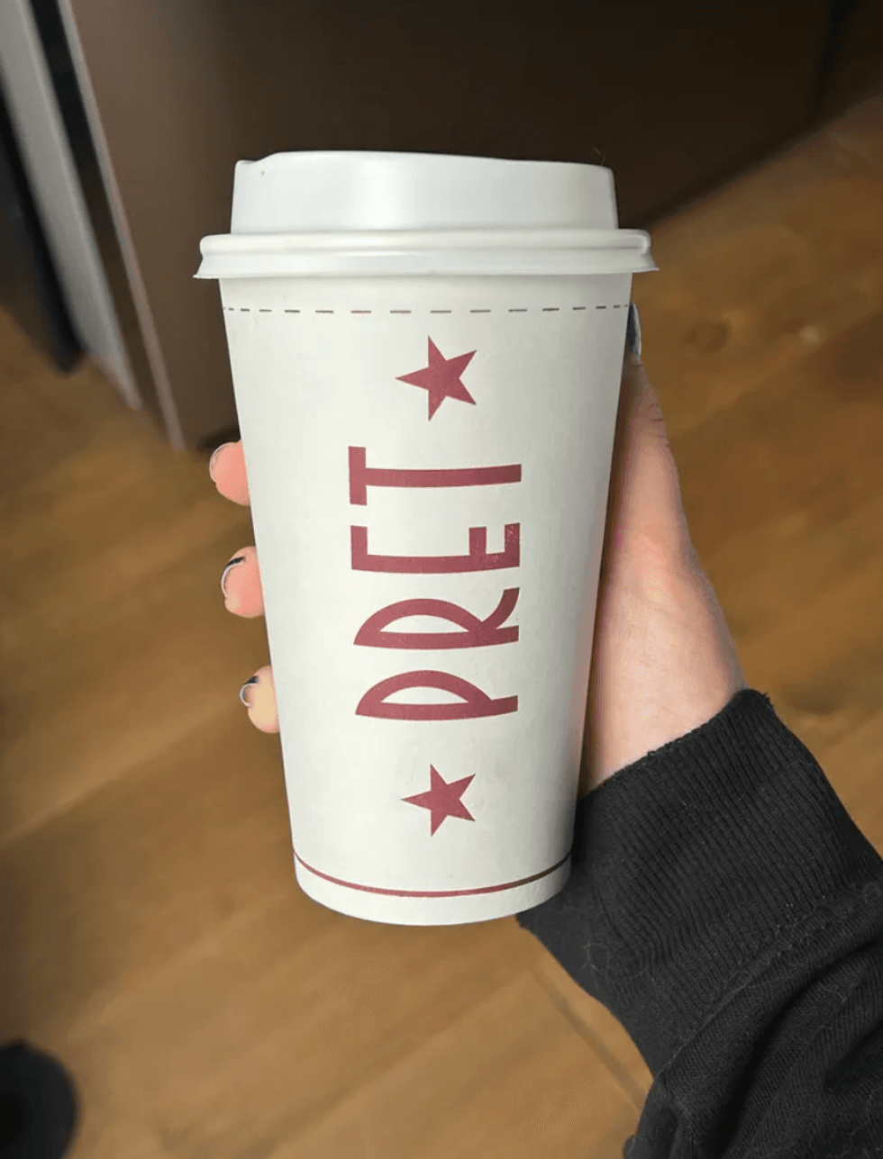 Person holding a coffee.