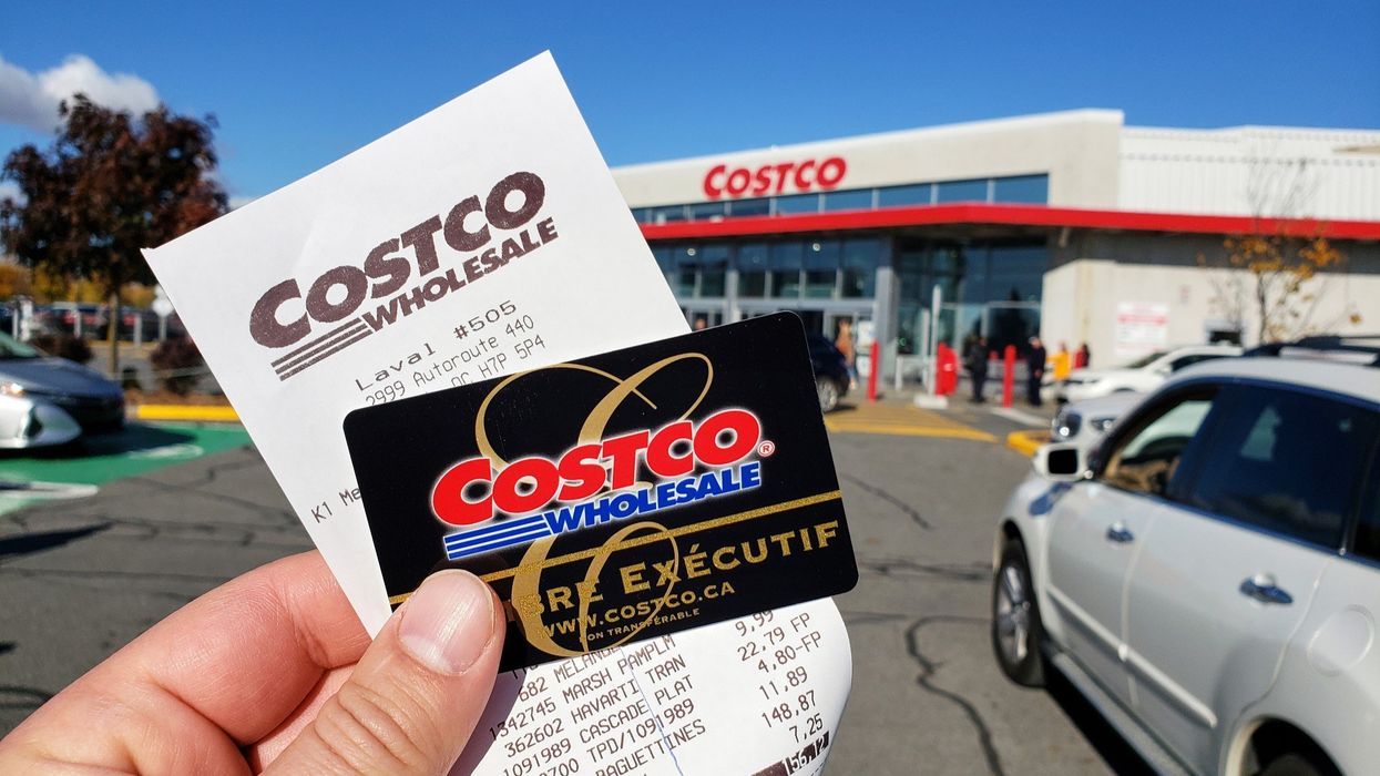Person holding a Costco membership card and receipt outside a location in Canada.
