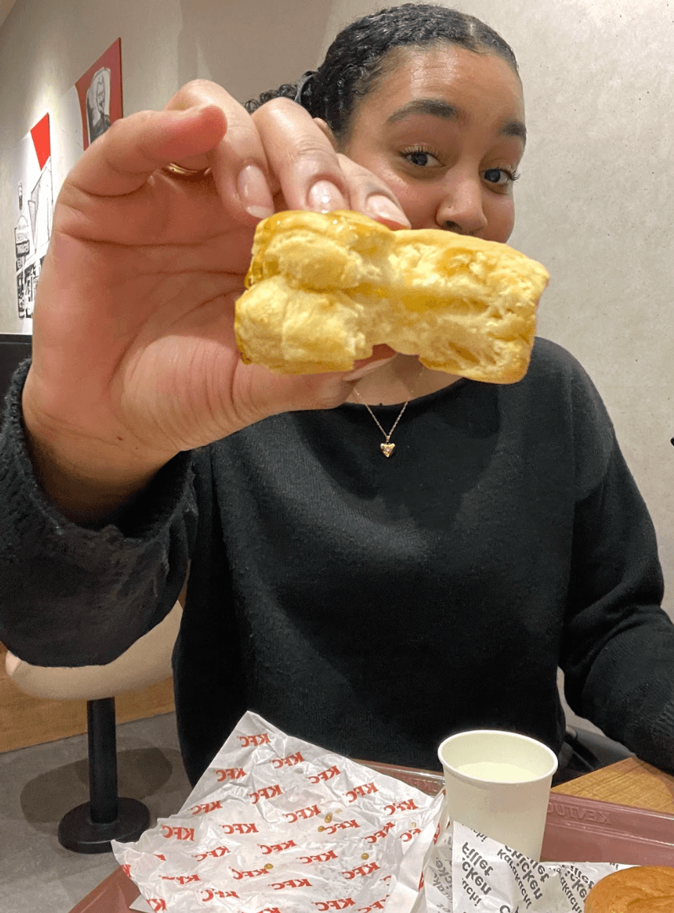 Person holding a KFC biscuit.