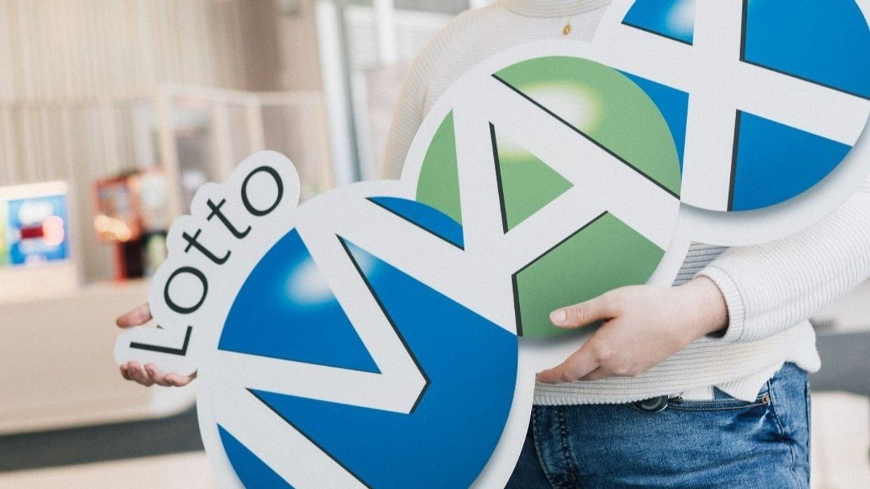 Person holding a Lotto Max sign.