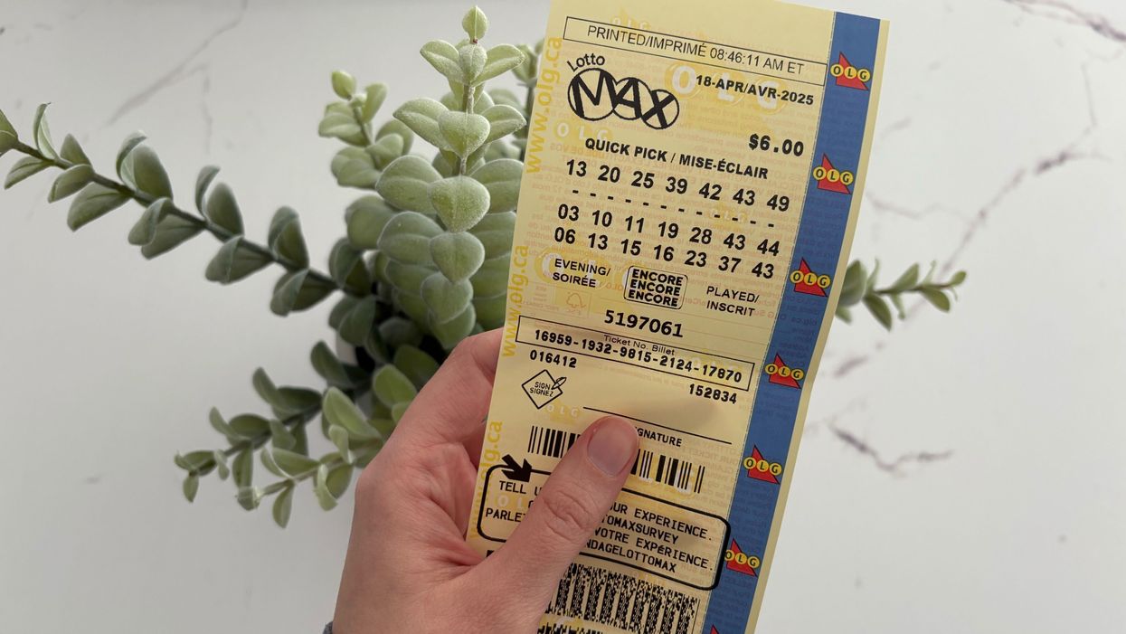 person holding a lotto max ticket from olg