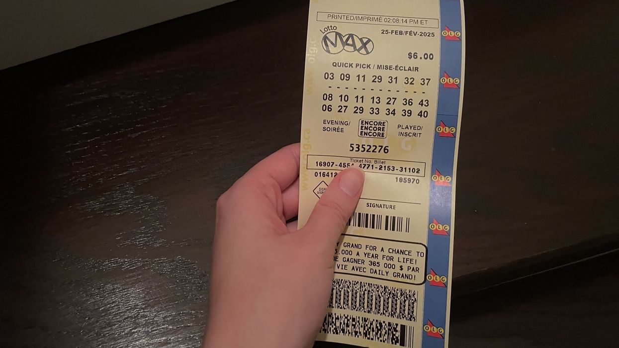 person holding a lotto max ticket