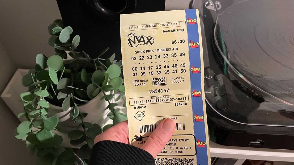 person holding a lotto max ticket