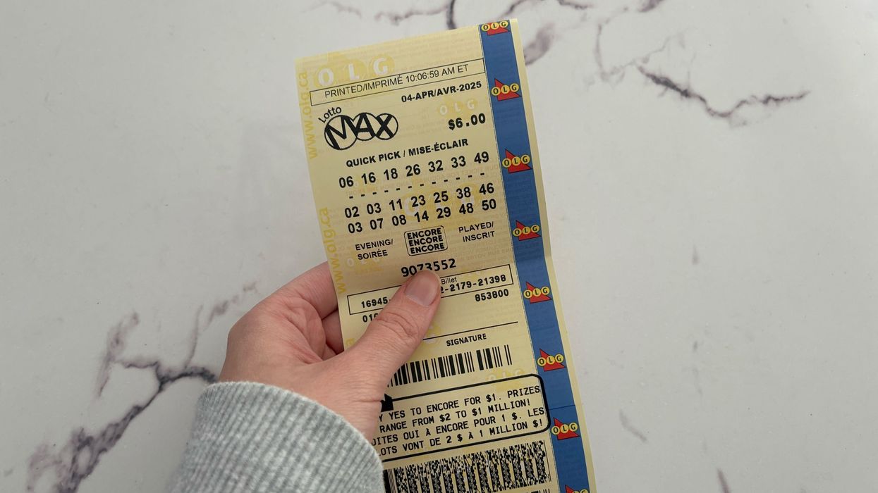 person holding a lotto max ticket