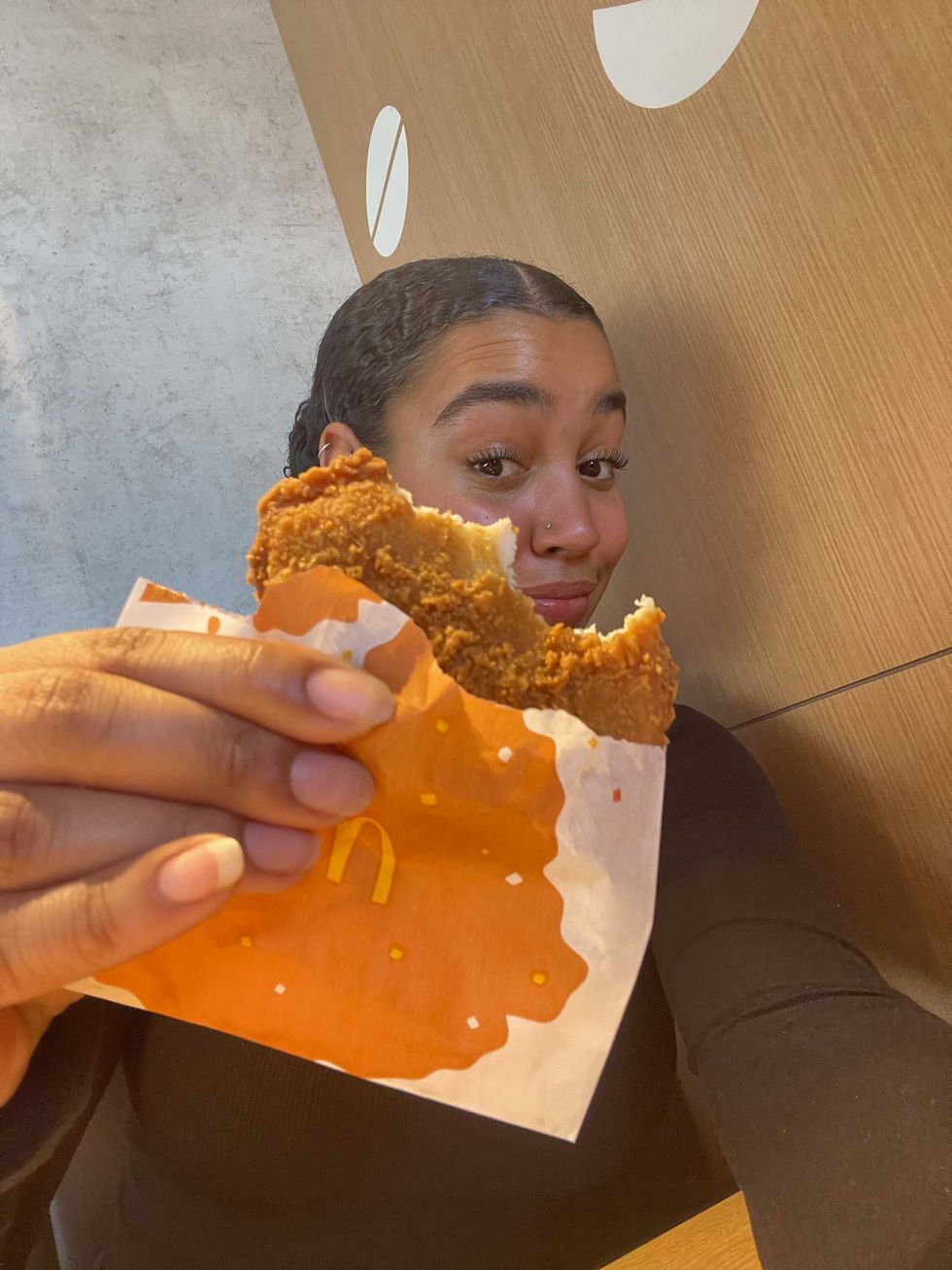 Person holding a Shaka-Chicki from McDonald's with a bite missing.