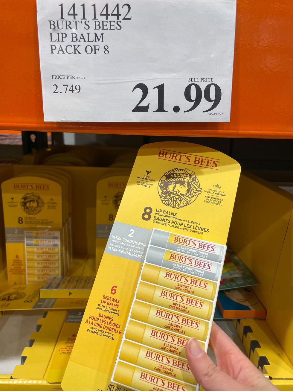 person holding a yellow pack of burt's bees lip balms