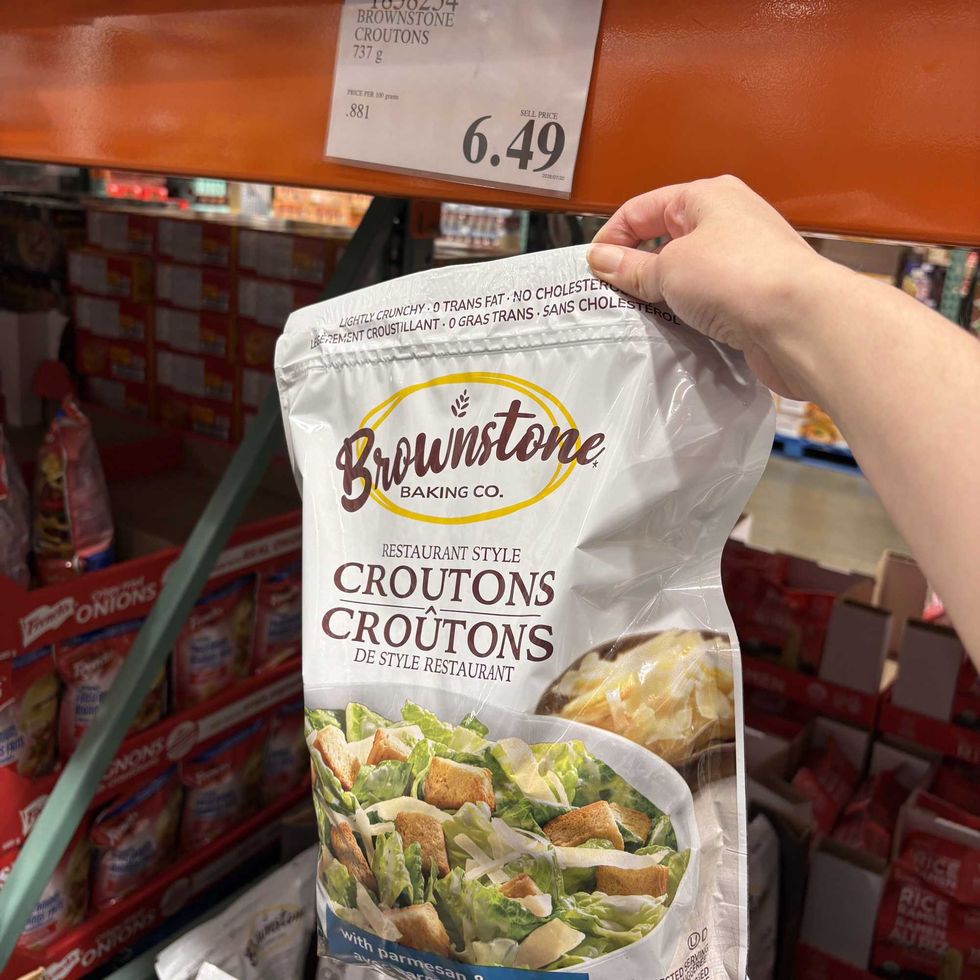 person holding bag of Brownstone croutons at Costco