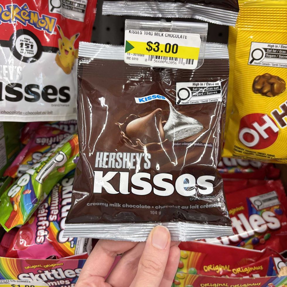 person holding bag of Hershey's Kisses at Dollarama