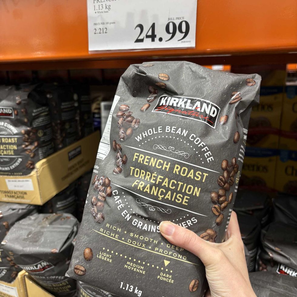person holding bag of Kirkland Signature French roast coffee at Costco