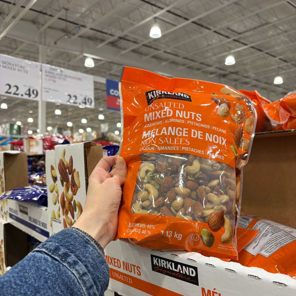 person holding bag of Kirkland Signature mixed nuts