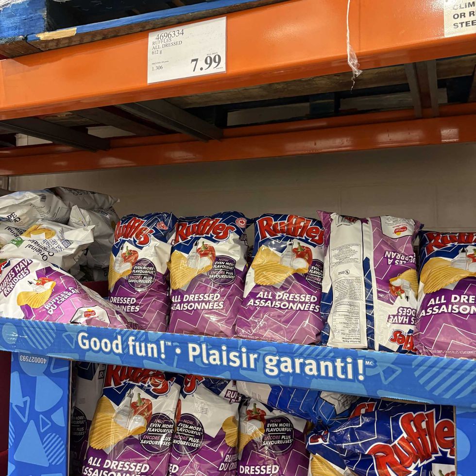 person holding bag of Ruffles all dressed chips at costco