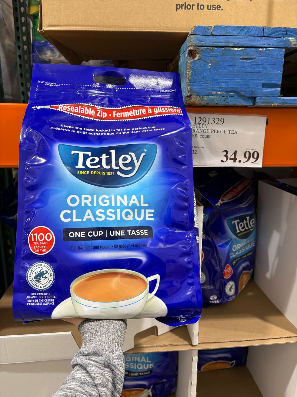 person holding bag of tetley tea at costco