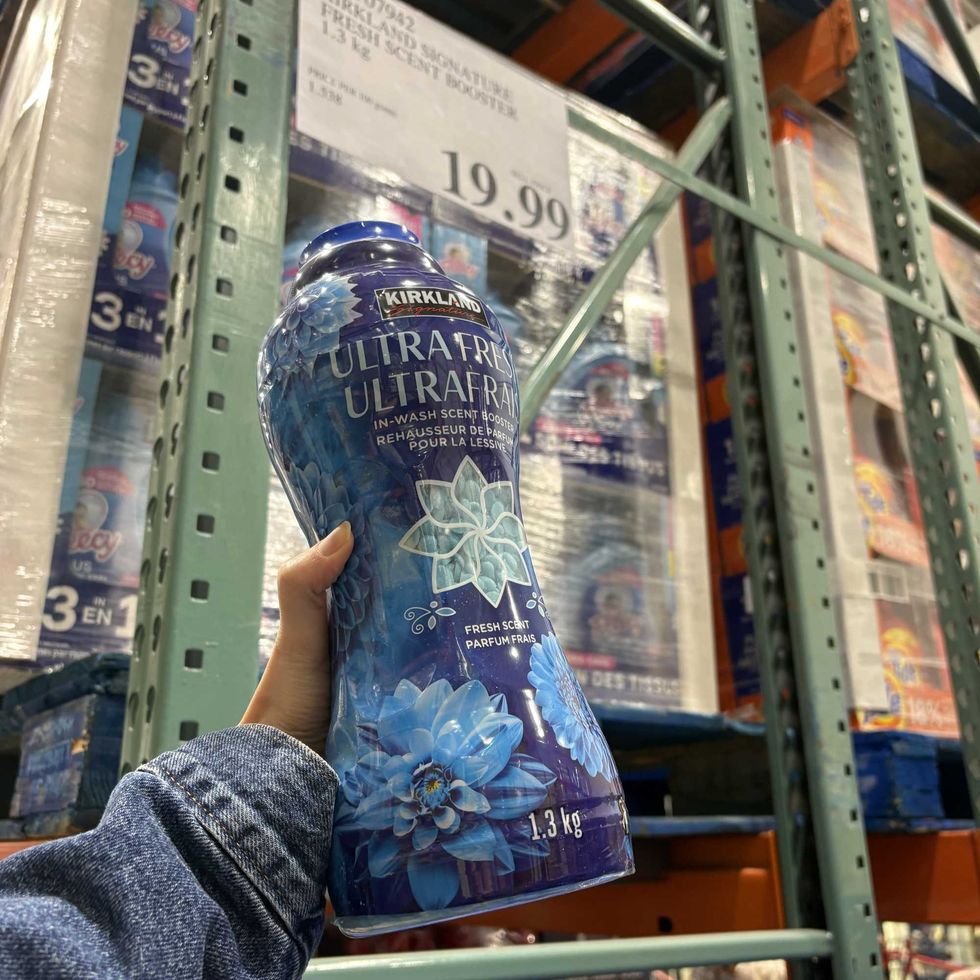 person holding bottle of Kirkland Signature laundry beads at costco