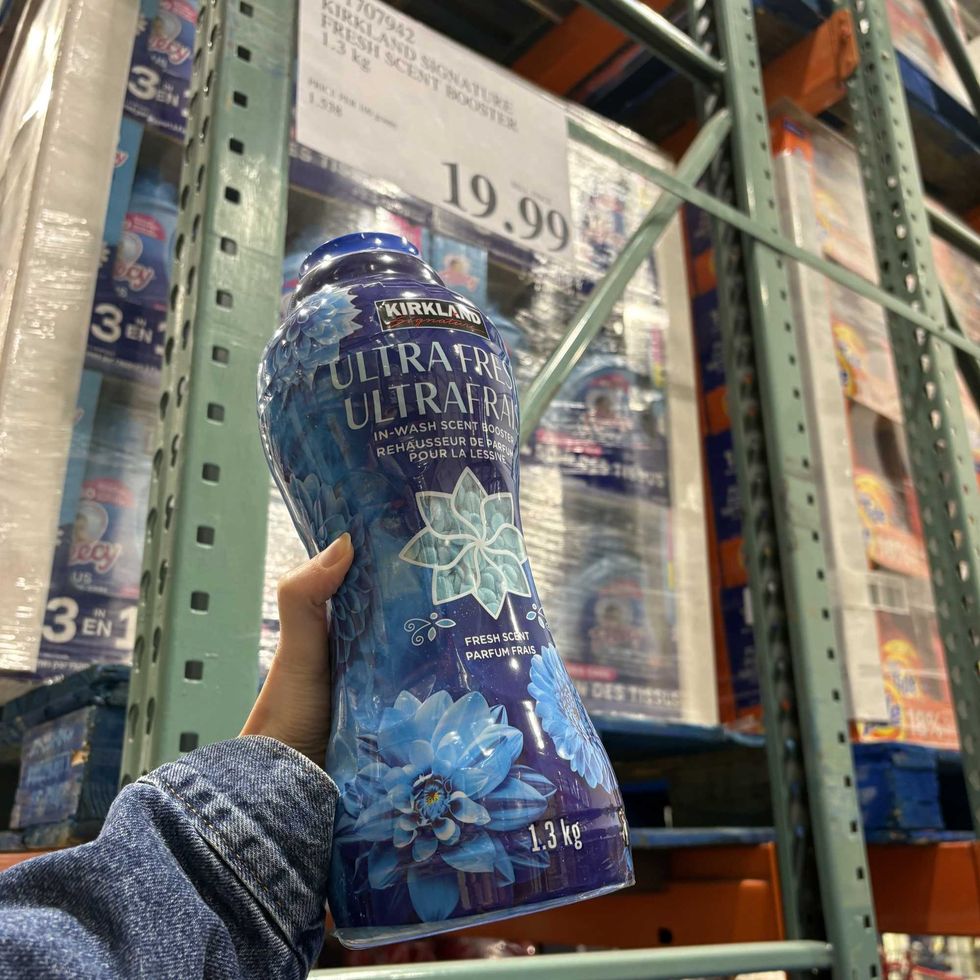 person holding bottle of Kirkland Signature ultra fresh laundry beads at costco