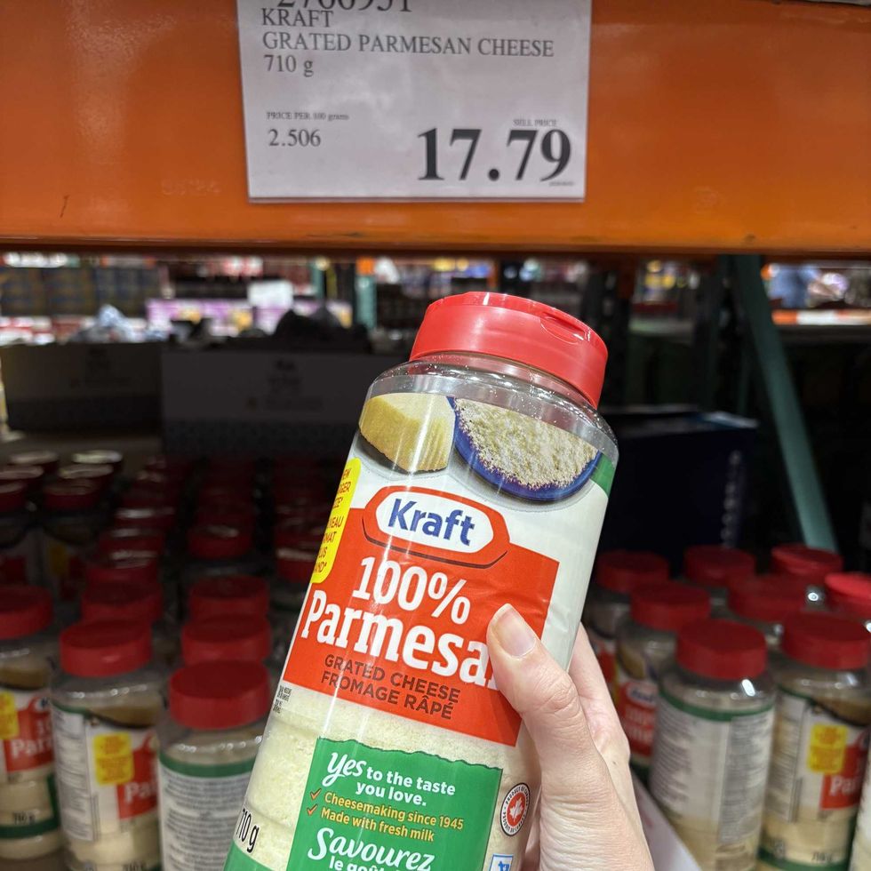person holding bottle of Kraft grated Parmesan cheese at Costco